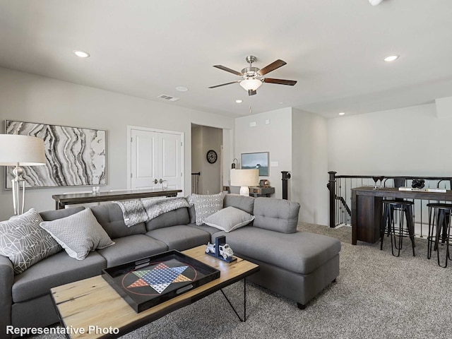 carpeted living room with ceiling fan