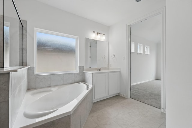 bathroom featuring tile patterned floors, a garden tub, and vanity