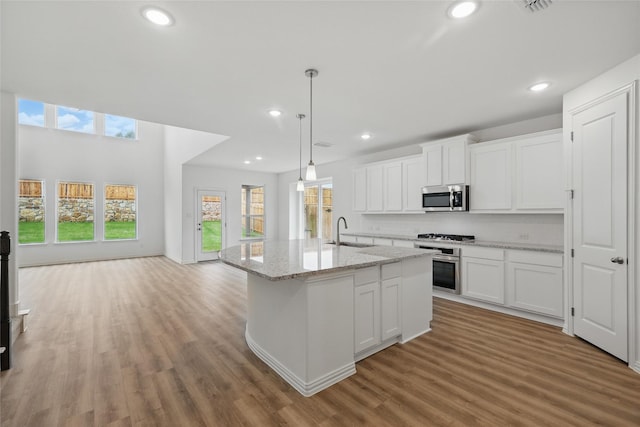 kitchen with recessed lighting, appliances with stainless steel finishes, white cabinetry, and a sink
