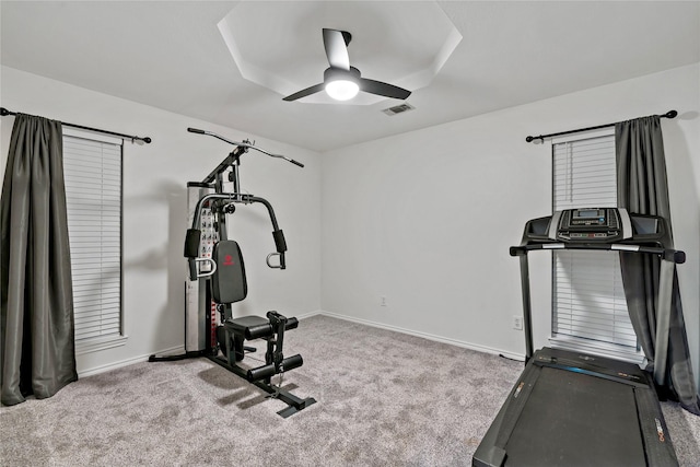 exercise room with ceiling fan and light carpet