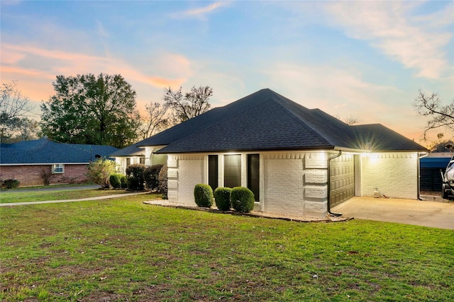 ranch-style house featuring a garage and a yard