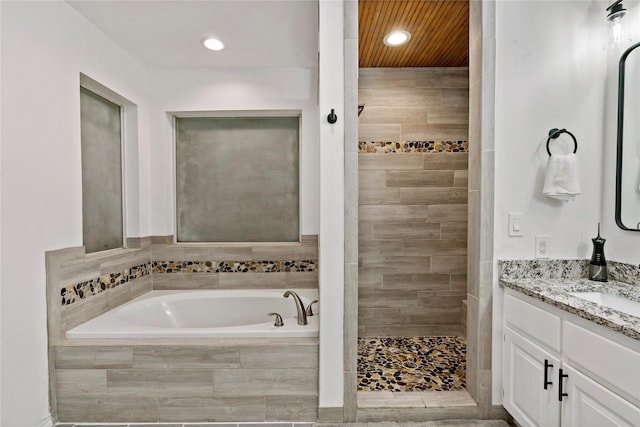 bathroom featuring separate shower and tub and vanity