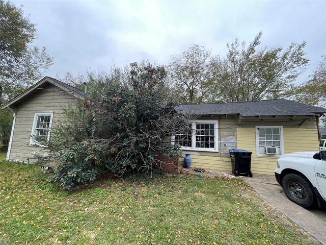 view of front of property with a front yard and cooling unit