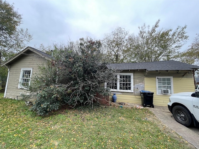 view of front of house featuring cooling unit and a front lawn