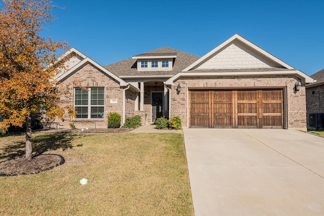 view of front of property featuring cooling unit, a front yard, and a garage