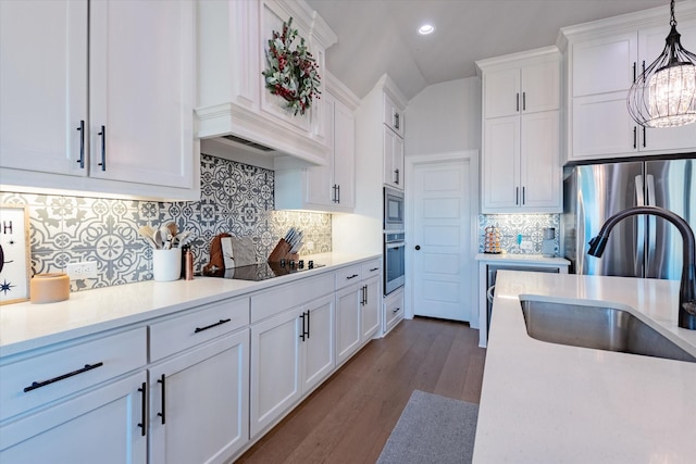 kitchen featuring white cabinetry, sink, dark hardwood / wood-style floors, decorative light fixtures, and appliances with stainless steel finishes