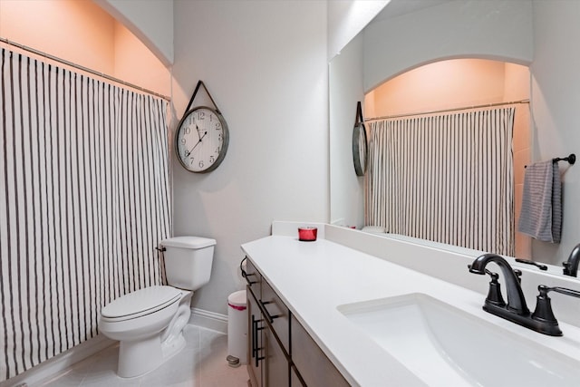 bathroom with tile patterned floors, vanity, toilet, and walk in shower