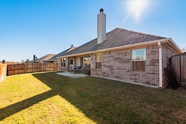 rear view of property featuring a lawn and a patio