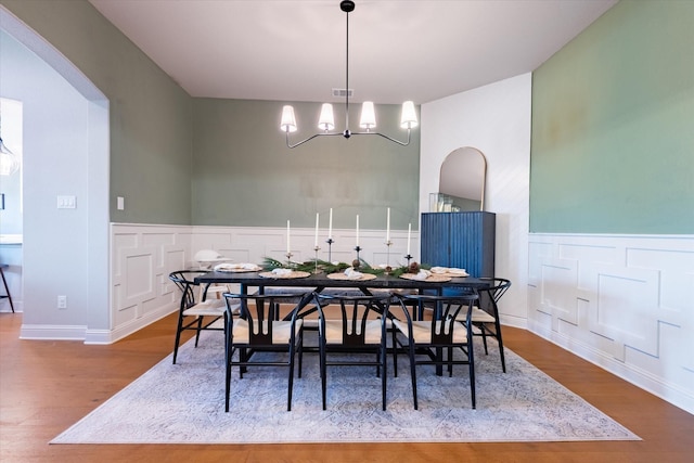 dining space featuring wood-type flooring and a chandelier