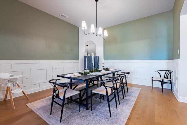 dining room with light hardwood / wood-style floors and a notable chandelier