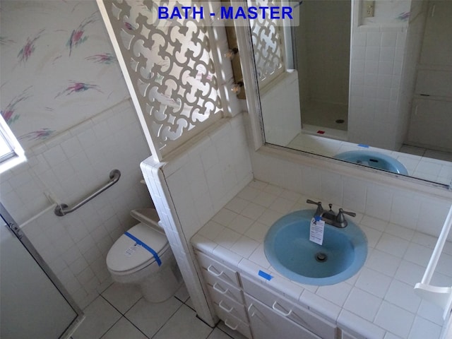 bathroom featuring tile patterned flooring, vanity, toilet, and tile walls