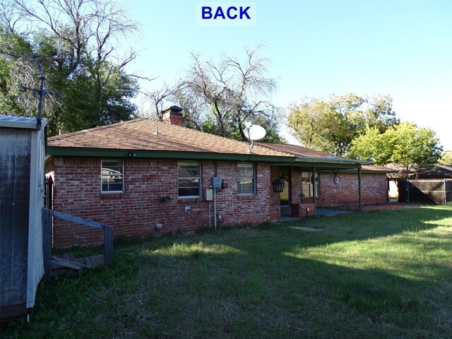 back of property featuring a lawn