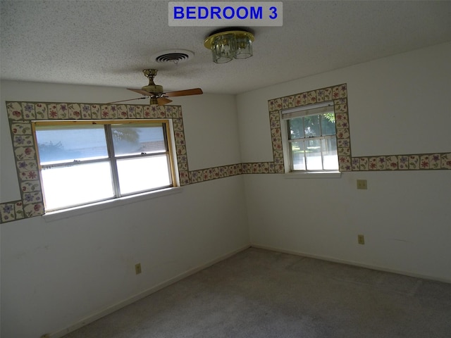 empty room featuring carpet, a textured ceiling, and ceiling fan