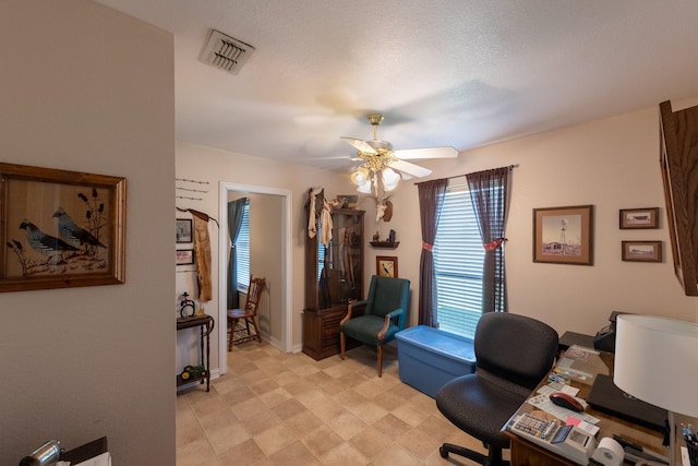 home office with ceiling fan and a textured ceiling