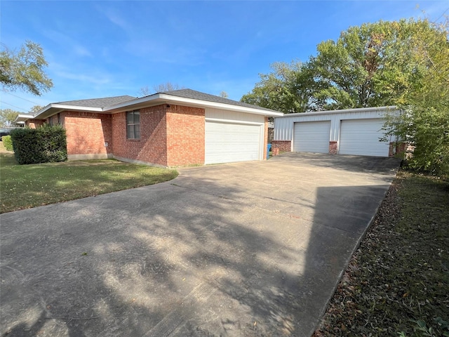 exterior space featuring a front lawn, an outdoor structure, and a garage