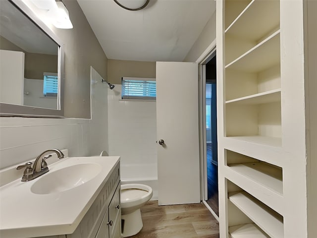 full bathroom with vanity, backsplash, tiled shower / bath, toilet, and wood-type flooring