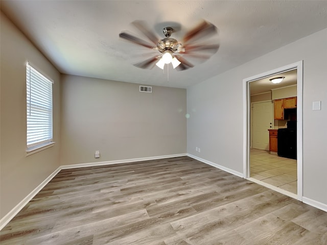 empty room featuring ceiling fan and light hardwood / wood-style flooring