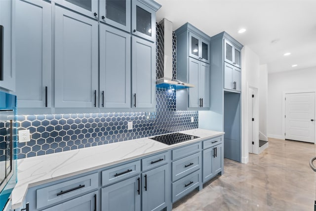 kitchen with light stone countertops, wall chimney exhaust hood, oven, decorative backsplash, and black electric stovetop