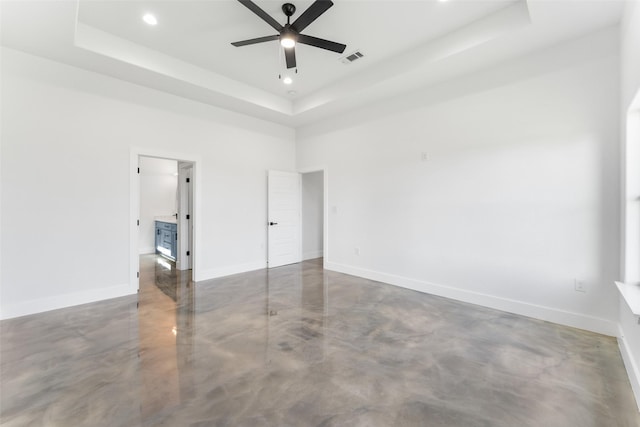 spare room featuring a tray ceiling, ceiling fan, and a high ceiling