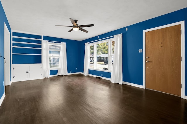 unfurnished living room featuring ceiling fan and dark wood-type flooring