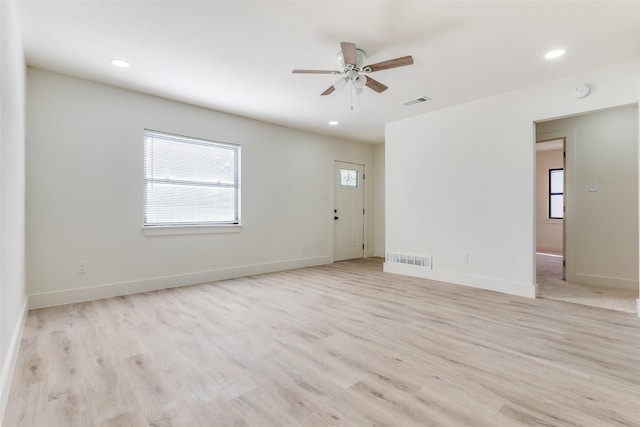 empty room with ceiling fan and light hardwood / wood-style floors