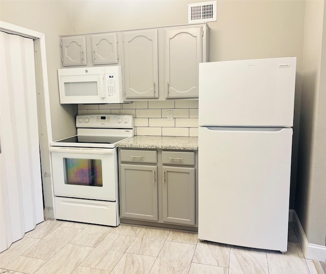 kitchen with gray cabinets, decorative backsplash, and white appliances