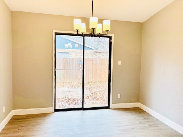 unfurnished dining area with light hardwood / wood-style floors and an inviting chandelier