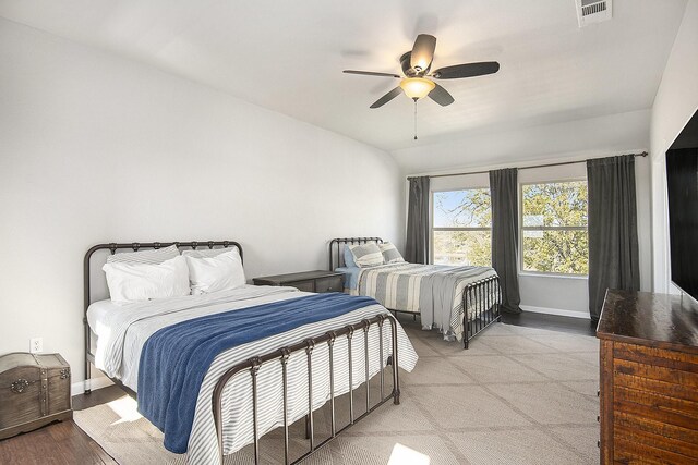 bedroom with light hardwood / wood-style floors, ceiling fan, and lofted ceiling