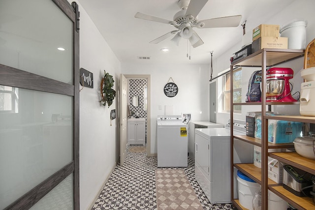 laundry area with washing machine and dryer, ceiling fan, and a barn door