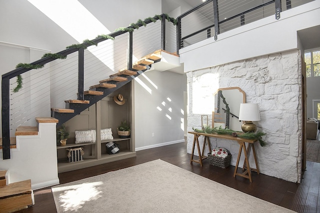 stairs with a high ceiling and wood-type flooring