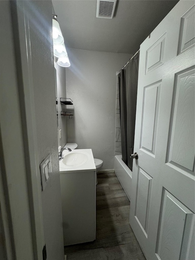 full bathroom with vanity, hardwood / wood-style flooring, toilet, and shower / tub combo with curtain