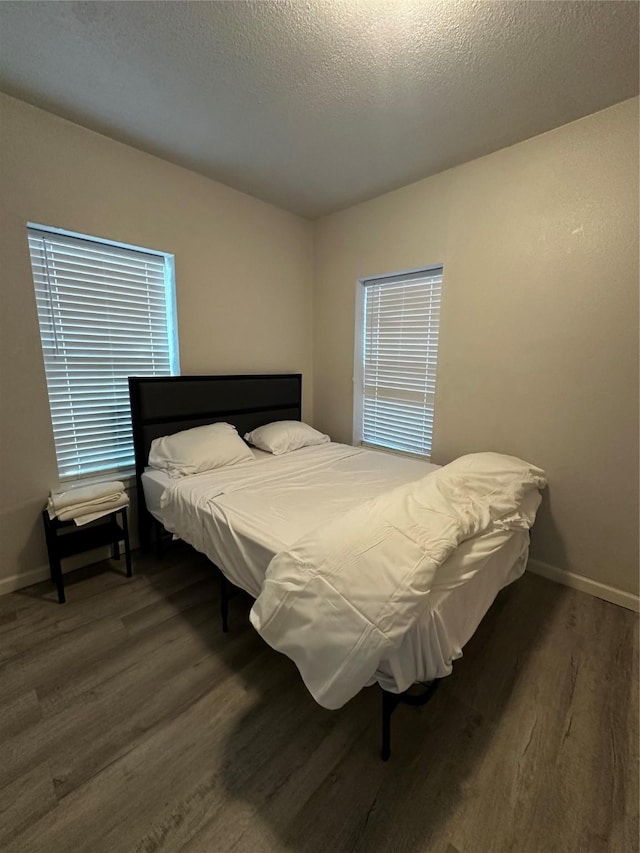 bedroom featuring a textured ceiling and dark wood-type flooring