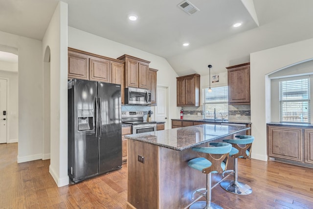 kitchen with a center island, light hardwood / wood-style floors, and stainless steel appliances