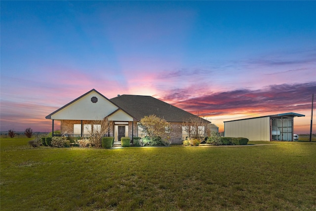 view of front of home featuring a lawn and an outbuilding