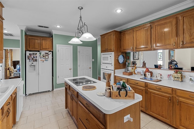 kitchen with pendant lighting, light tile patterned floors, white appliances, crown molding, and a center island