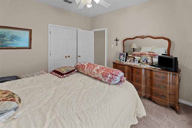 bedroom with ceiling fan, light colored carpet, and a closet