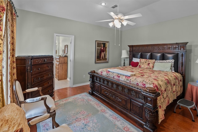 bedroom featuring ceiling fan, connected bathroom, and light hardwood / wood-style floors