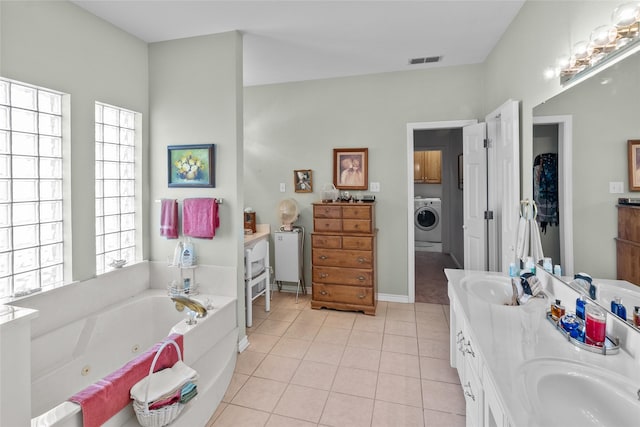 bathroom with tile patterned floors, washer / clothes dryer, vanity, and a tub