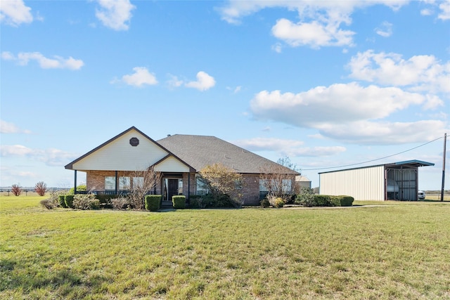 rear view of house with an outdoor structure and a yard