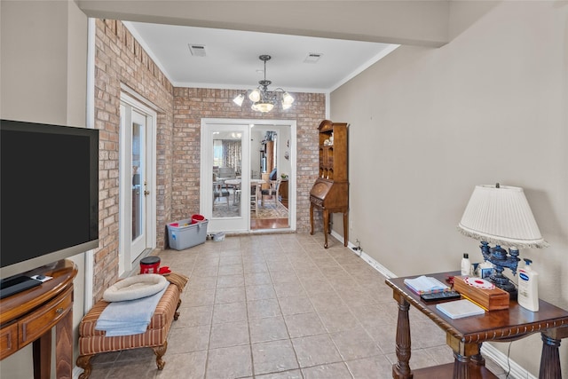 interior space featuring crown molding, brick wall, a chandelier, and french doors