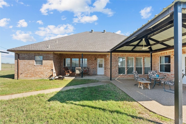 back of property with a yard and a patio area