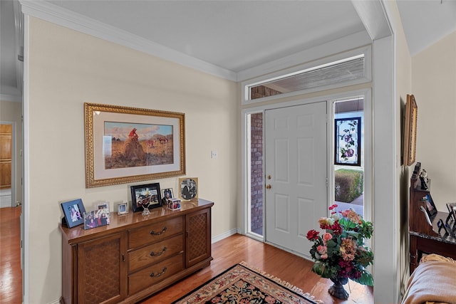 foyer with ornamental molding and light wood-type flooring