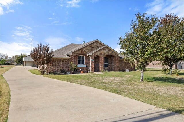 ranch-style home with an outbuilding, a front yard, and a garage