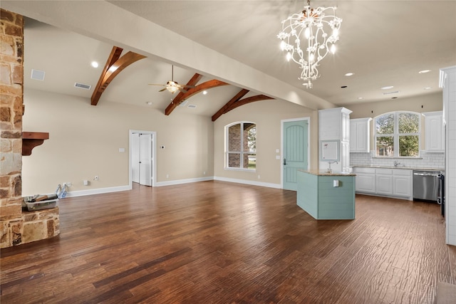 unfurnished living room with dark wood-type flooring, a stone fireplace, sink, vaulted ceiling with beams, and ceiling fan with notable chandelier