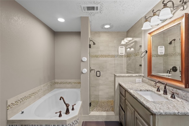 bathroom featuring vanity, independent shower and bath, tile patterned flooring, and a textured ceiling