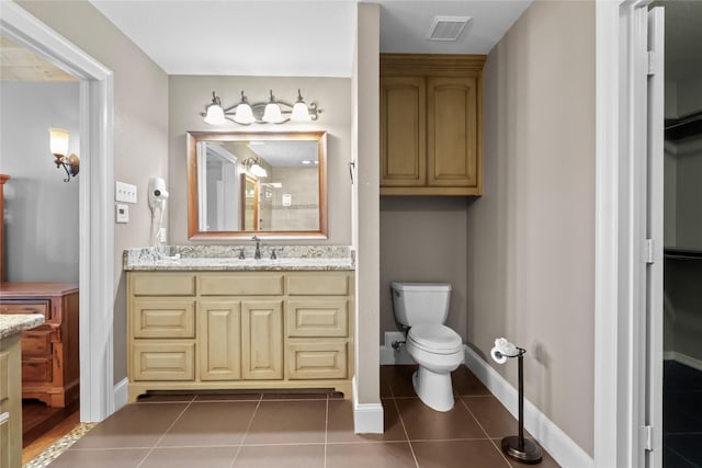 bathroom with vanity, tile patterned flooring, and toilet