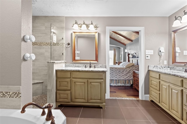 bathroom with vanity, vaulted ceiling, a washtub, and tile patterned floors