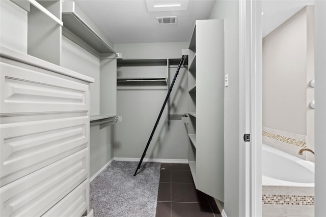 walk in closet with dark tile patterned floors