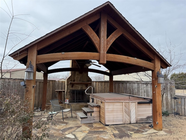 view of patio featuring a gazebo and an outdoor stone fireplace