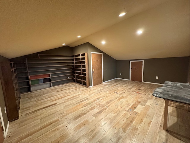 additional living space featuring lofted ceiling and light wood-type flooring